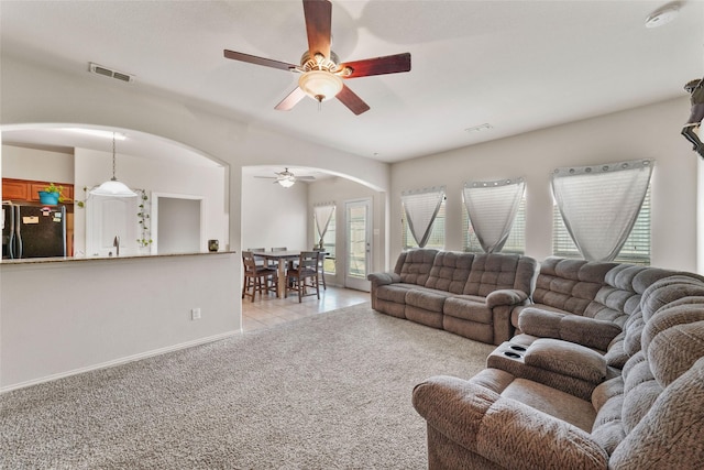 carpeted living room featuring ceiling fan