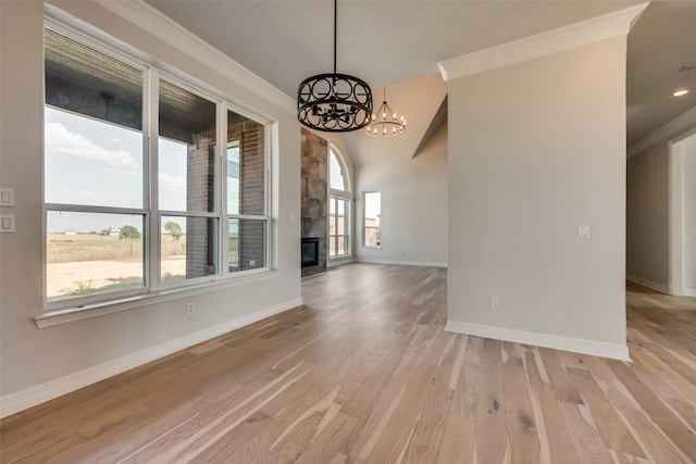 spare room featuring a chandelier, light wood-type flooring, and ornamental molding