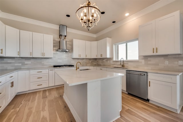 kitchen with a kitchen island with sink, stainless steel appliances, light hardwood / wood-style floors, wall chimney exhaust hood, and decorative backsplash