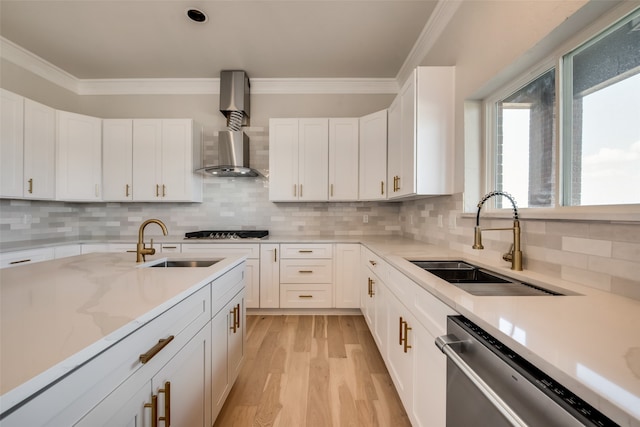 kitchen with light wood-type flooring, wall chimney range hood, white cabinets, stainless steel dishwasher, and decorative backsplash