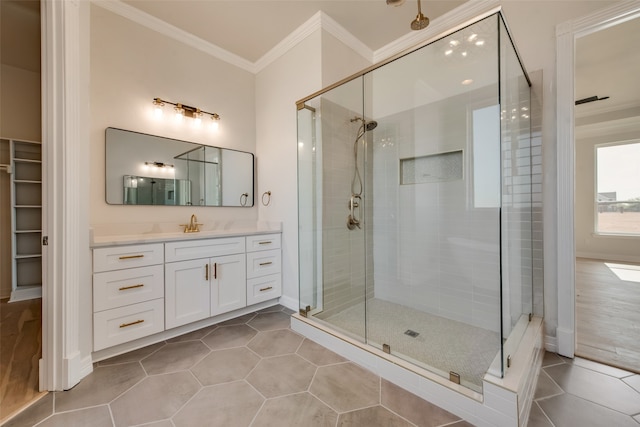 bathroom featuring vanity, walk in shower, crown molding, and tile patterned floors