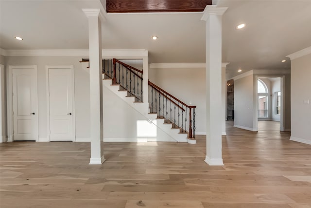 stairway featuring ornamental molding, ornate columns, and hardwood / wood-style floors