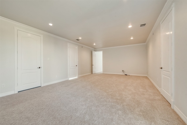 spare room featuring ornamental molding and light colored carpet