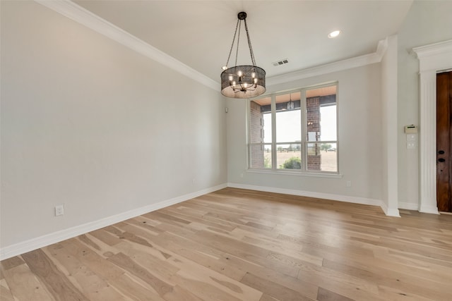 spare room with a notable chandelier, light hardwood / wood-style flooring, and crown molding