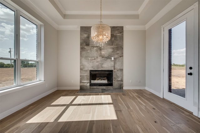 unfurnished living room with hardwood / wood-style flooring and a tray ceiling