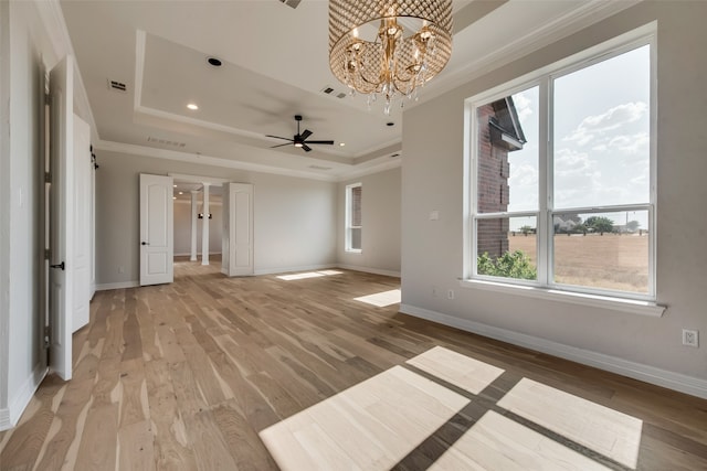 unfurnished room with light hardwood / wood-style flooring, ceiling fan with notable chandelier, crown molding, and a raised ceiling