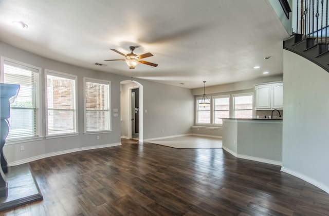 unfurnished living room with ceiling fan, dark hardwood / wood-style flooring, and sink