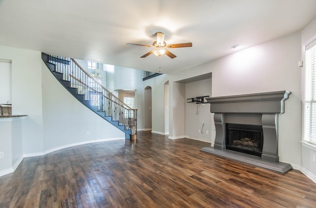 unfurnished living room featuring ceiling fan and dark hardwood / wood-style floors