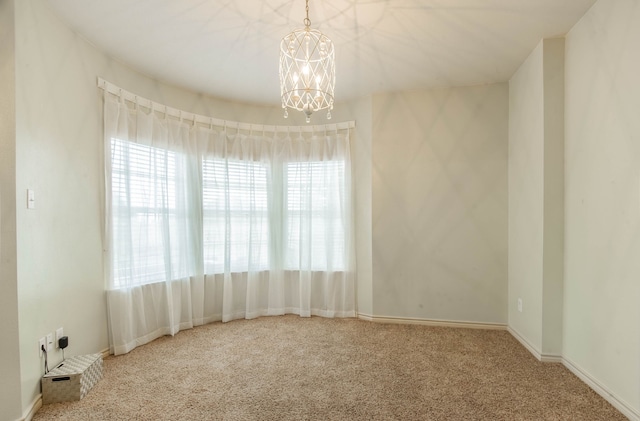 spare room with carpet and a notable chandelier