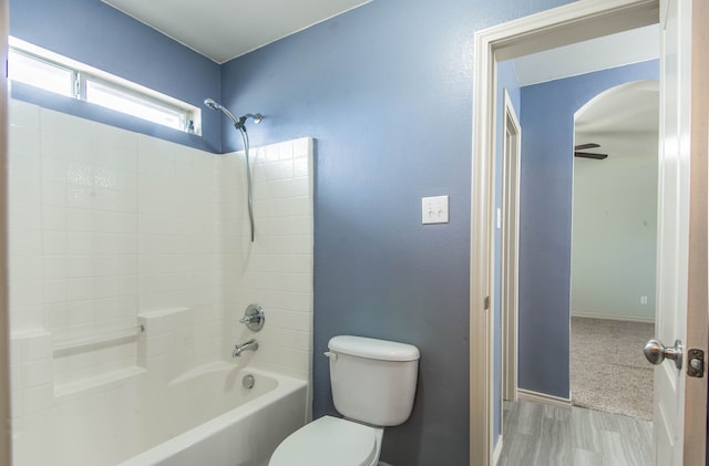 bathroom featuring hardwood / wood-style flooring, ceiling fan, shower / bathtub combination, and toilet