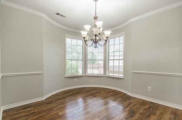 spare room with crown molding, dark wood-type flooring, and a notable chandelier