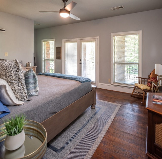 bedroom featuring dark hardwood / wood-style floors, ceiling fan, access to outside, and multiple windows