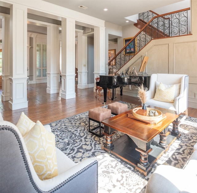 living room featuring dark wood-type flooring and decorative columns