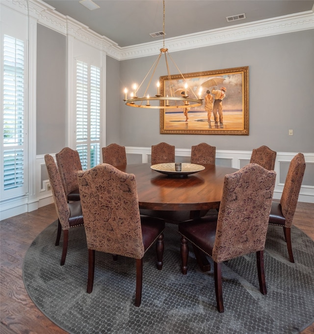 dining space featuring dark hardwood / wood-style flooring, an inviting chandelier, a wealth of natural light, and crown molding