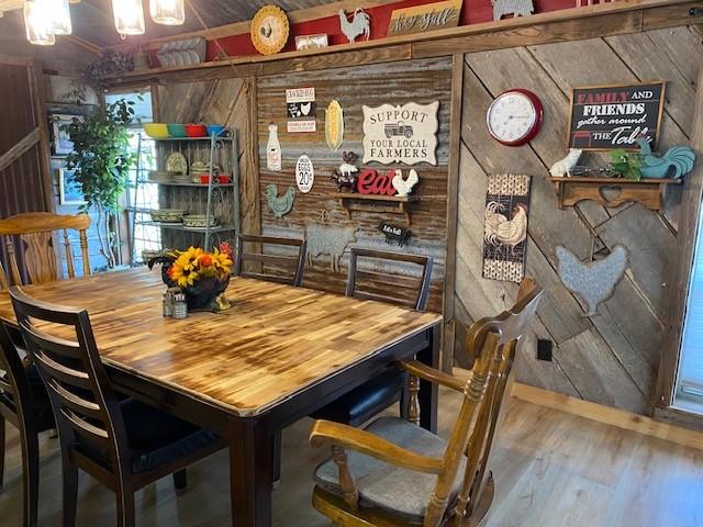 dining room featuring wooden walls and hardwood / wood-style flooring