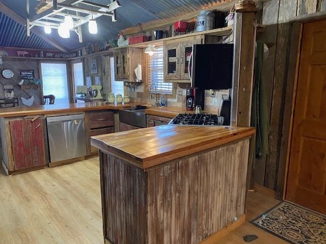 kitchen featuring dishwasher, sink, kitchen peninsula, light hardwood / wood-style floors, and butcher block counters