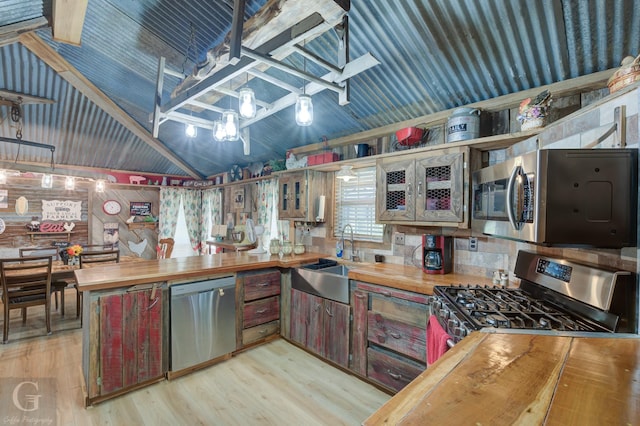 kitchen featuring wood counters, sink, appliances with stainless steel finishes, and light hardwood / wood-style flooring