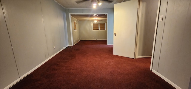 hallway featuring dark colored carpet and crown molding