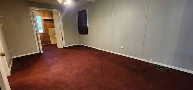 unfurnished bedroom with dark colored carpet