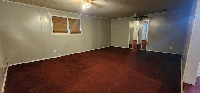 spare room with dark colored carpet and ceiling fan