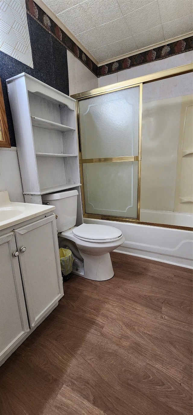 full bathroom with vanity, shower / bath combination with glass door, toilet, and hardwood / wood-style flooring