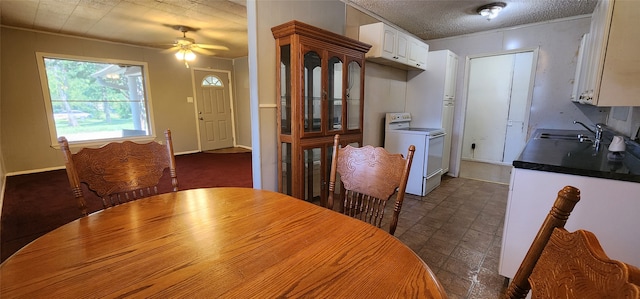 dining room with ceiling fan, dark tile patterned floors, sink, washer / clothes dryer, and a textured ceiling