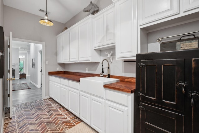 kitchen featuring sink, white cabinetry, and hanging light fixtures