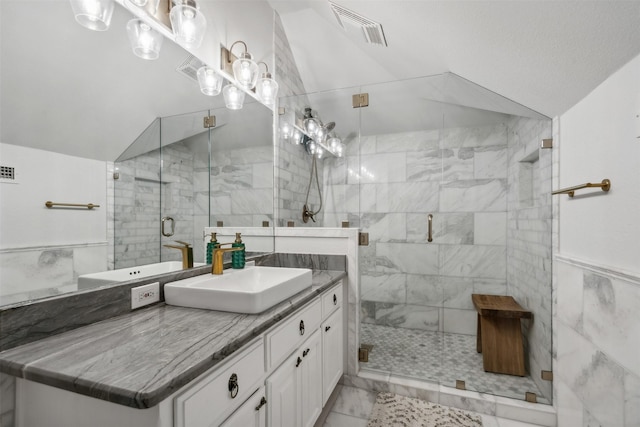 bathroom featuring tile walls, a shower with door, lofted ceiling, and vanity