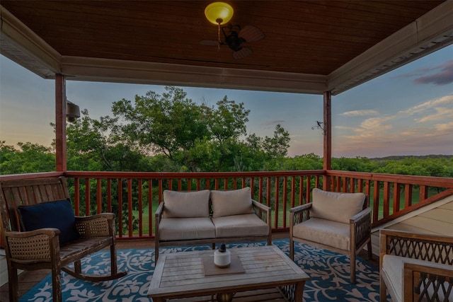 deck at dusk featuring an outdoor living space and ceiling fan