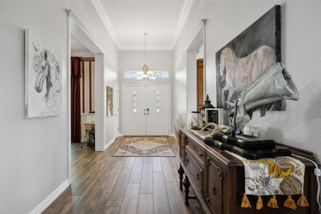 entrance foyer featuring a notable chandelier, hardwood / wood-style flooring, and ornamental molding