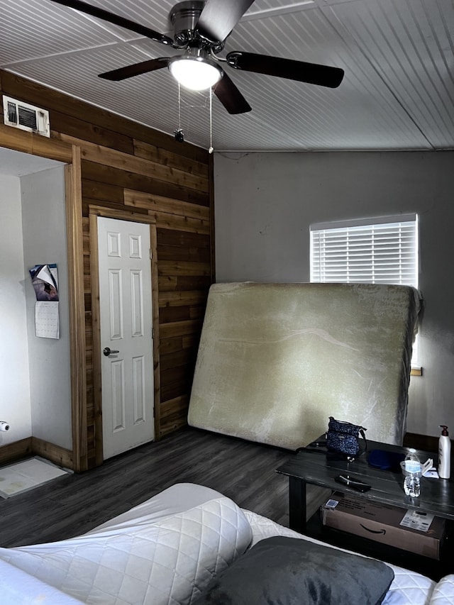 bedroom with ceiling fan and wooden walls