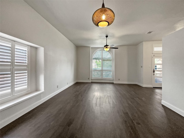 spare room with ceiling fan, a healthy amount of sunlight, and dark hardwood / wood-style floors