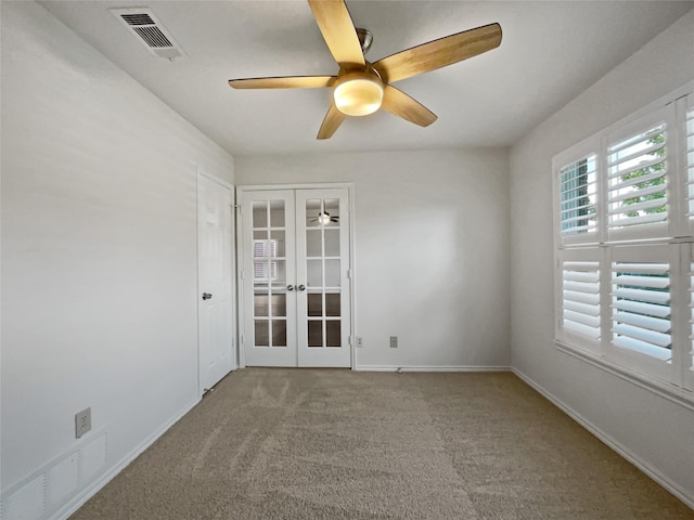 unfurnished room with ceiling fan, french doors, and carpet floors