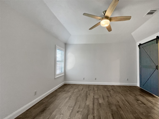 interior space with ceiling fan, lofted ceiling, a barn door, and dark hardwood / wood-style floors