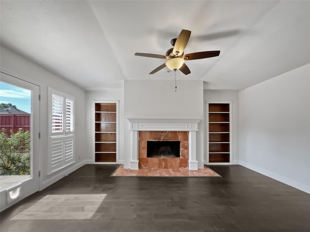 unfurnished living room with a high end fireplace, ceiling fan, and dark hardwood / wood-style floors