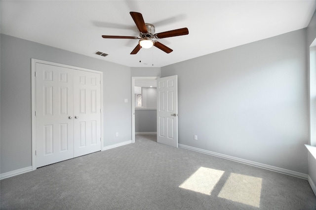 unfurnished bedroom featuring carpet flooring, ceiling fan, and a closet