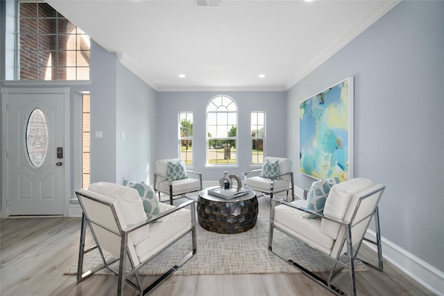 living room featuring light hardwood / wood-style floors and crown molding