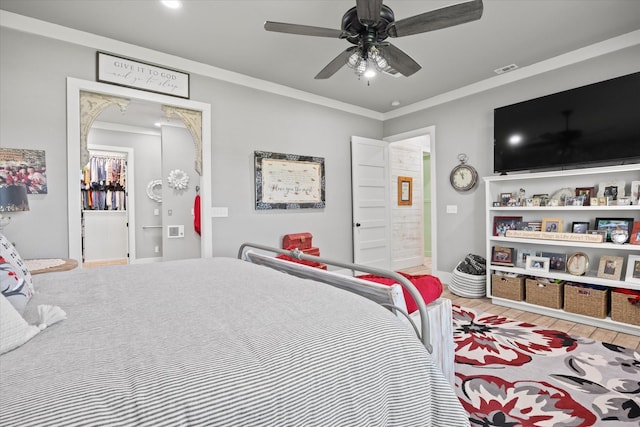 bedroom featuring hardwood / wood-style flooring, ceiling fan, and ornamental molding