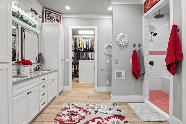 bathroom with vanity and tiled shower