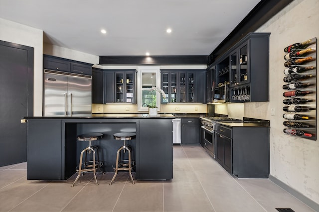 bar featuring high end appliances and light tile patterned floors