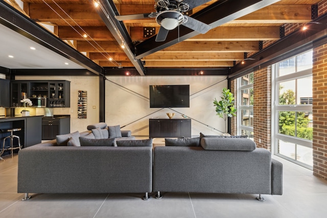 living room with tile patterned floors, ceiling fan, beamed ceiling, brick wall, and wood ceiling