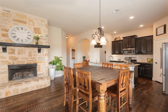 dining space featuring sink and a stone fireplace