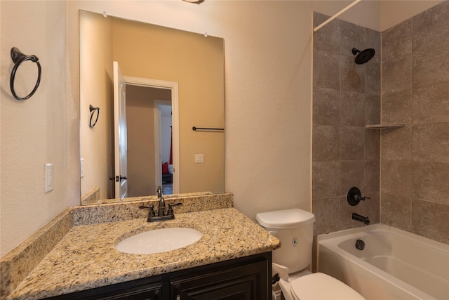 full bathroom with vanity, tiled shower / bath, and toilet