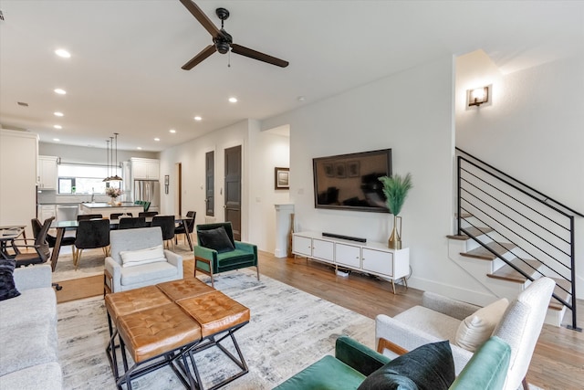 living room with light hardwood / wood-style flooring, sink, and ceiling fan