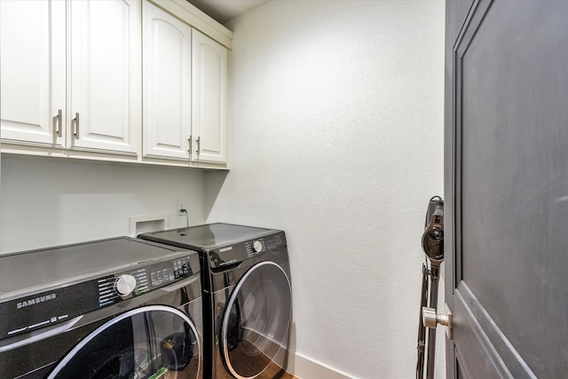 laundry room with washing machine and dryer and cabinets