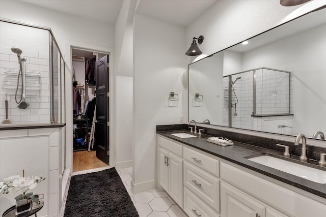 bathroom featuring a shower with shower door, wood-type flooring, and dual vanity