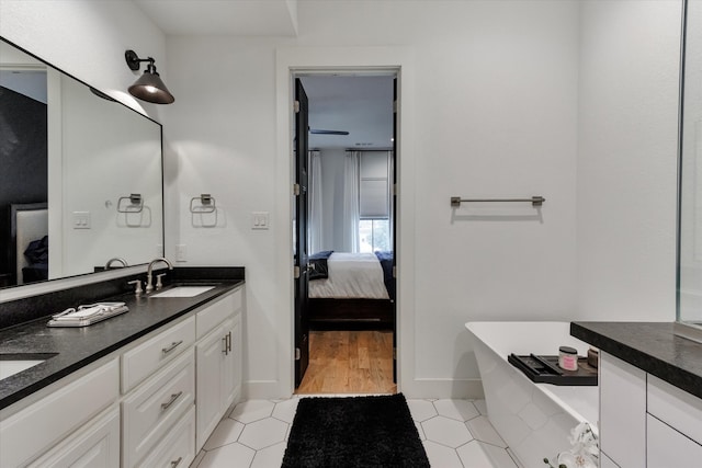 bathroom with tile patterned flooring, a washtub, and dual bowl vanity