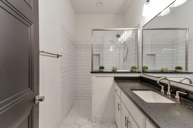 bathroom featuring tile patterned flooring, a shower with door, and vanity