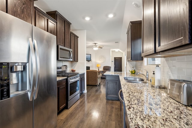 kitchen featuring light stone countertops, sink, ceiling fan, dark wood-type flooring, and stainless steel appliances