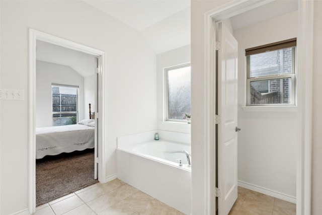 bathroom featuring tile patterned floors, a bathtub, and lofted ceiling